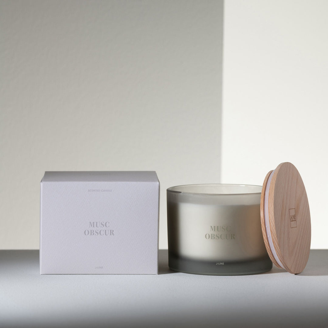 Musc Obscur candle displayed with packaging in a minimal, modern setting.