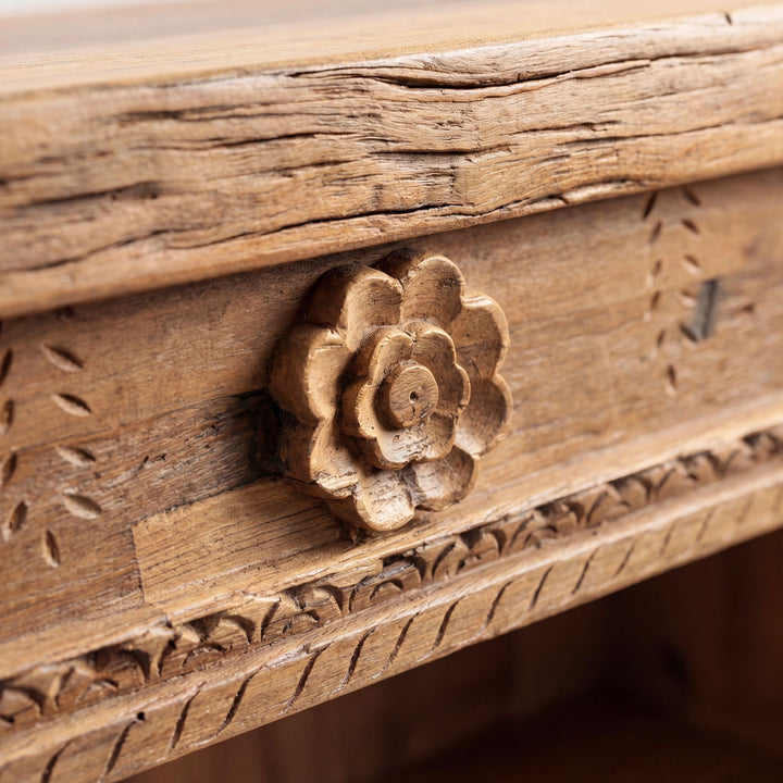 Close-up detail of the carved wooden flower motif on the drawer front.