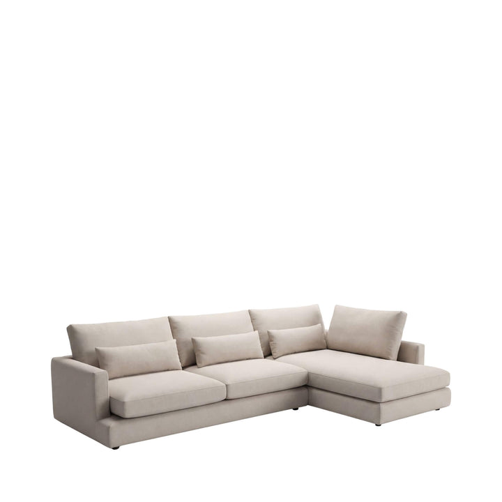 Front view of the Naxos sofa showing its spacious chaise design and soft neutral upholstery.