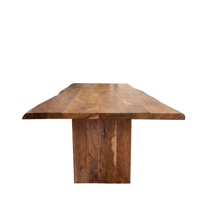 Angled view of the dining table highlighting its bold base and natural acacia finish.