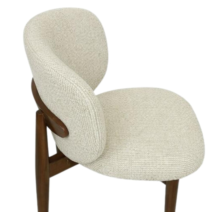 Rear three-quarter view of the Nolan chair showing the sculptural backrest and oak wood legs.