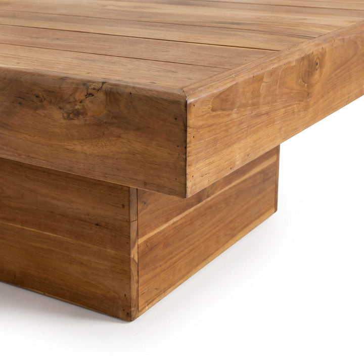Close-up of the Oahu coffee table showing its thick teak wood top and architectural pedestal base