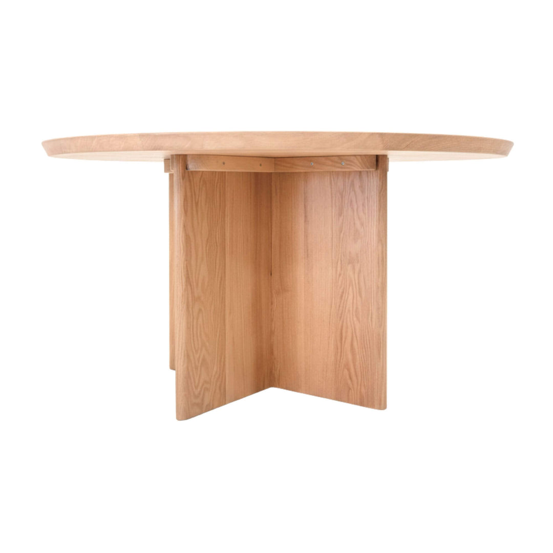 Angled studio shot of the oak round dining table showing its X-leg structure.