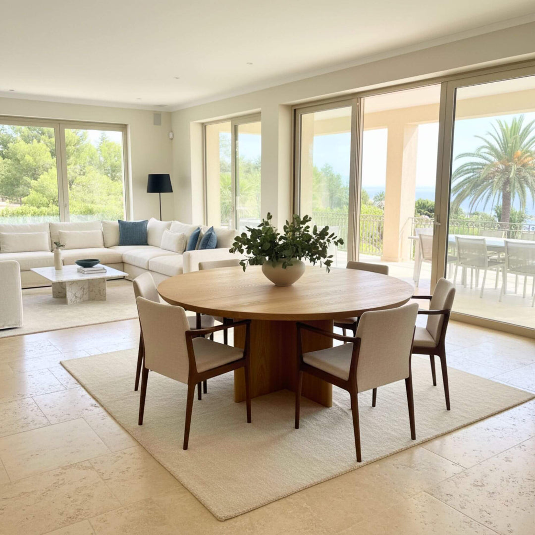 Angled studio shot of the oak round dining table showing its X-leg structure.