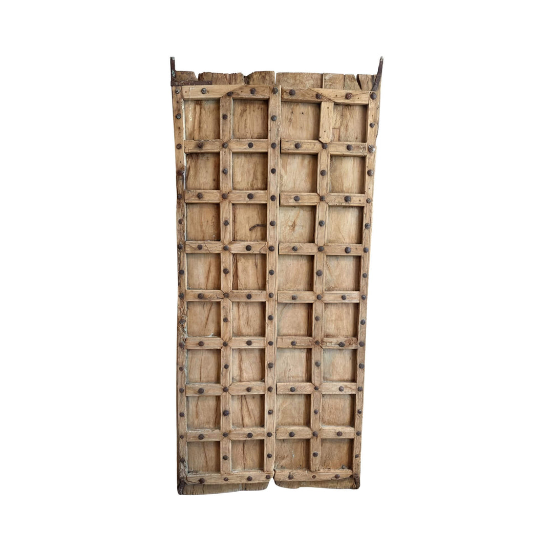 Front view of the Old Door Briss Collection showing its reclaimed sheesham wood panels and metal studs.