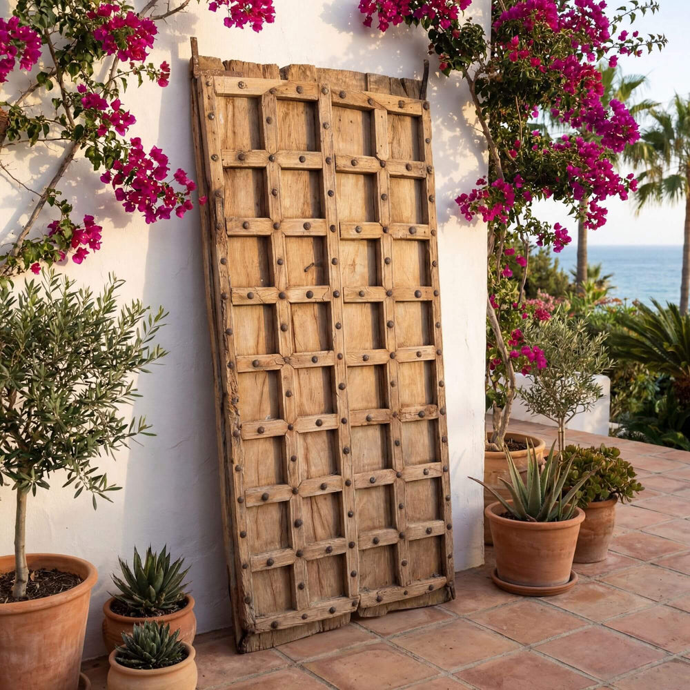 Front view of the Old Door Briss Collection showing its reclaimed sheesham wood panels and metal studs.