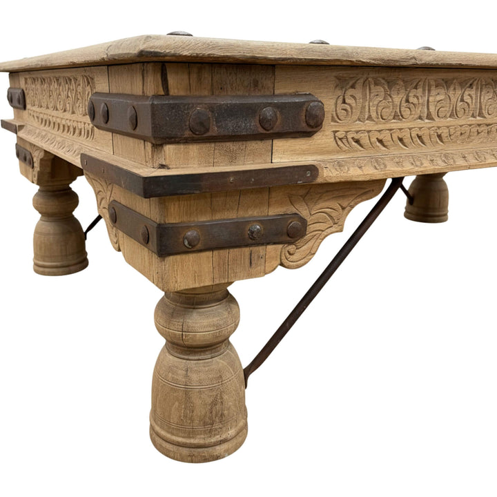 Low-angle shot of the carved legs and reclaimed wood structure of the Old India table.