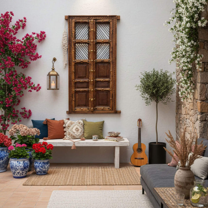 Outdoor terrace scene with the Olmen Window styled among plants and boho décor.
