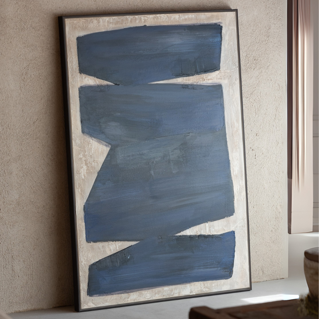 Abstract painting with blue brushstrokes on a beige wall