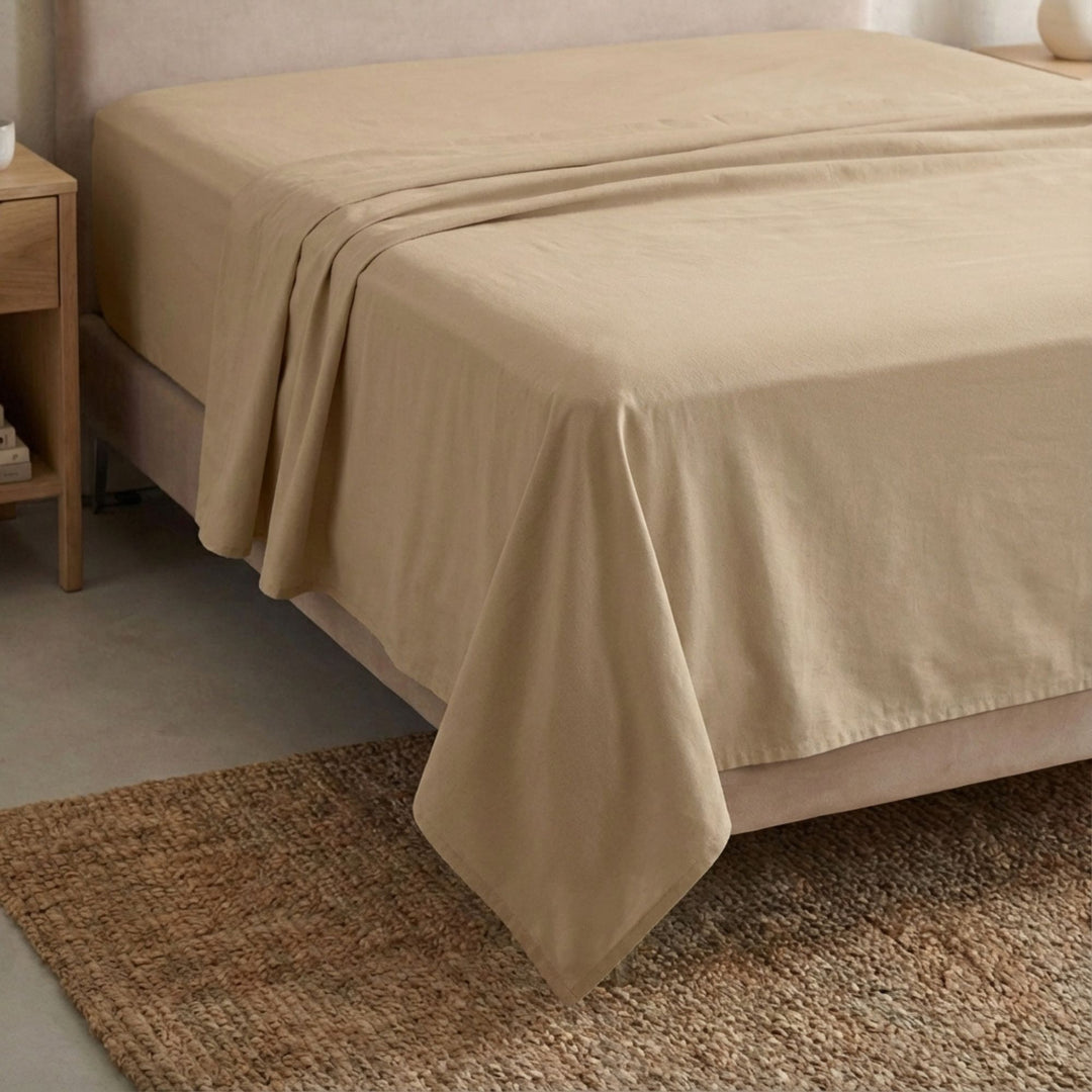 Full view of the Opera top sheet draped over a bed, showcasing its fluid cotton-linen texture.