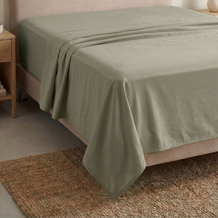 Full view of the Opera top sheet draped over a bed, showcasing its fluid cotton-linen texture.