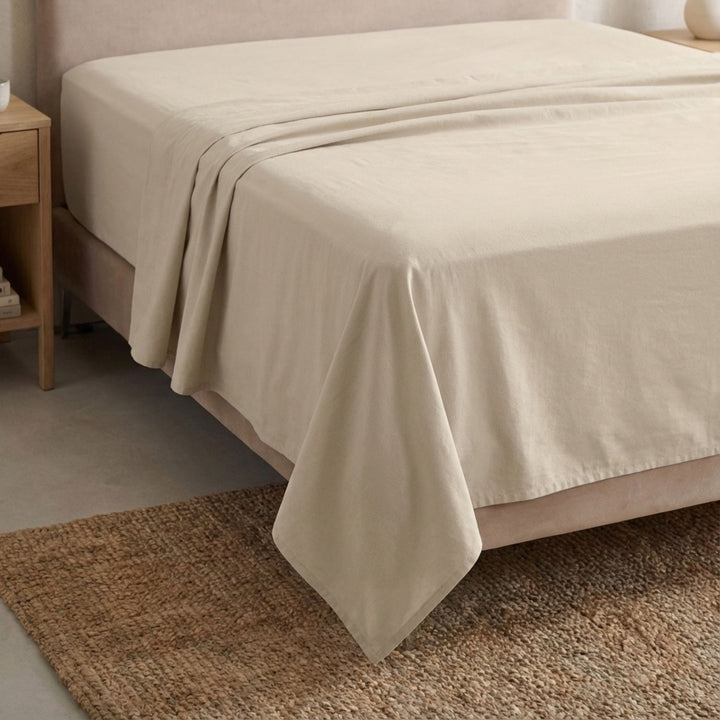 Full view of the Opera top sheet draped over a bed, showcasing its fluid cotton-linen texture.