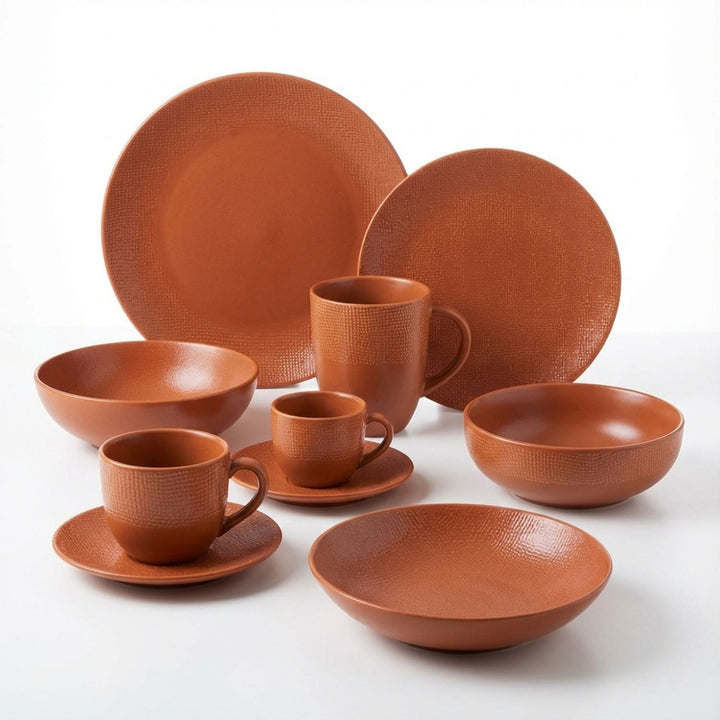 Orange Vesuvio ceramic tableware set with plates, bowls, cups, and mugs.