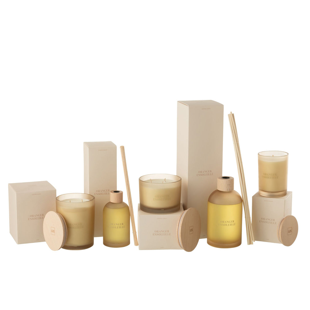 Group display of Oranger Ensoleillé diffusers and candles on a styled tabletop.