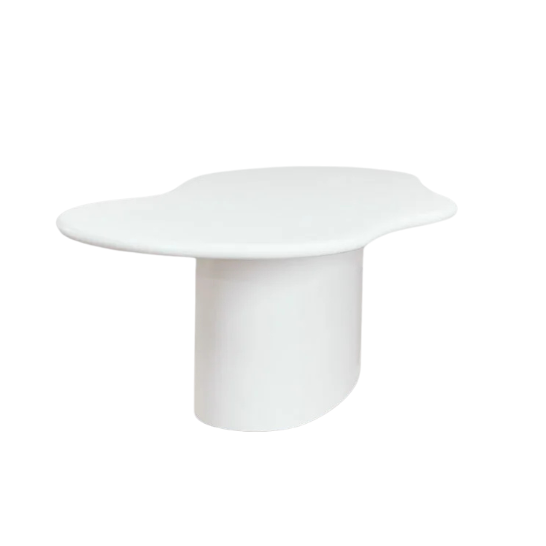 Angled view of the dining table highlighting its rounded silhouette and monolithic base.