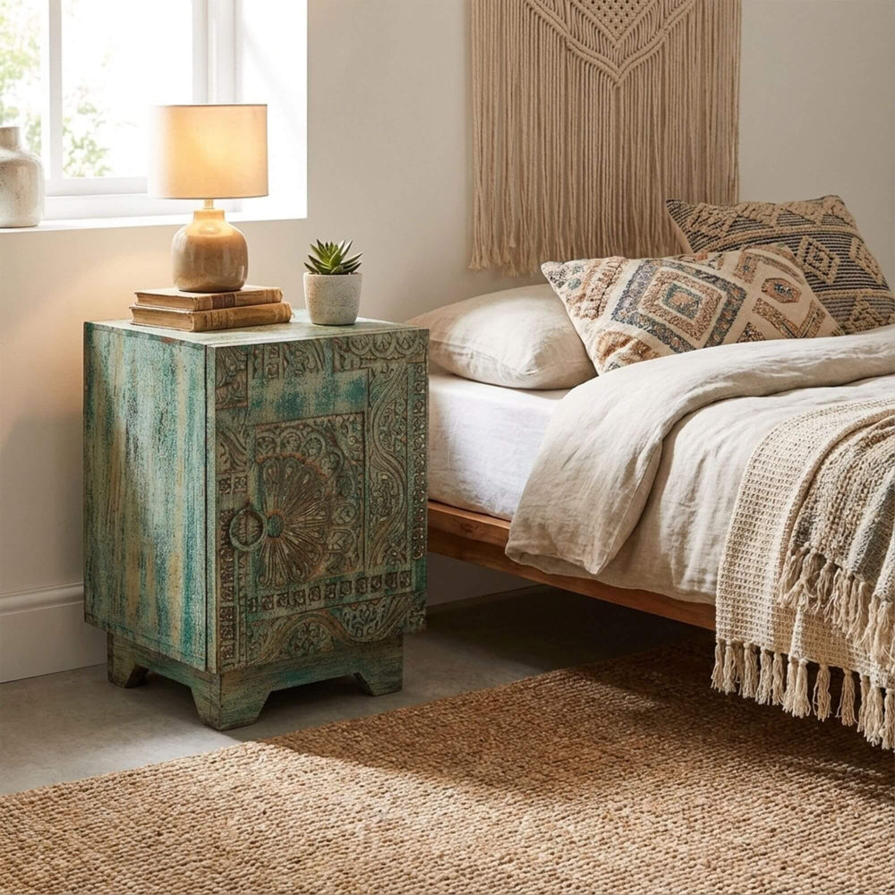 Decorative Pachmarhi nightstand next to a bed with patterned headboard and pillows in a bedroom setting.