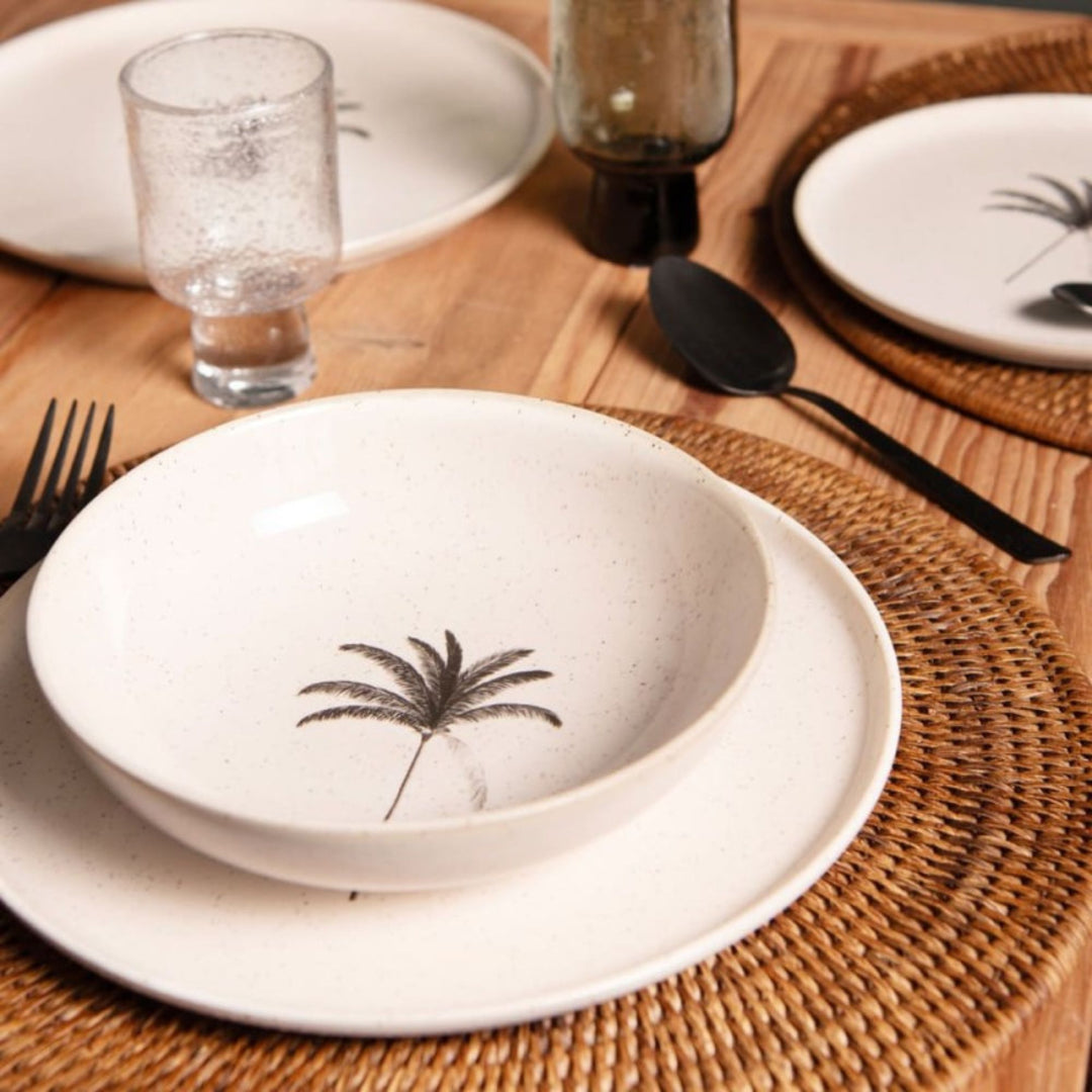 Palm ceramic bowl and plate styled on a natural rattan placemat for Mediterranean dining
