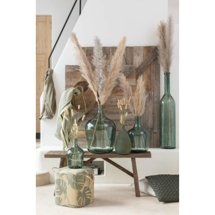 Interior styled with natural pampa leaves in glass vases and neutral decor.
