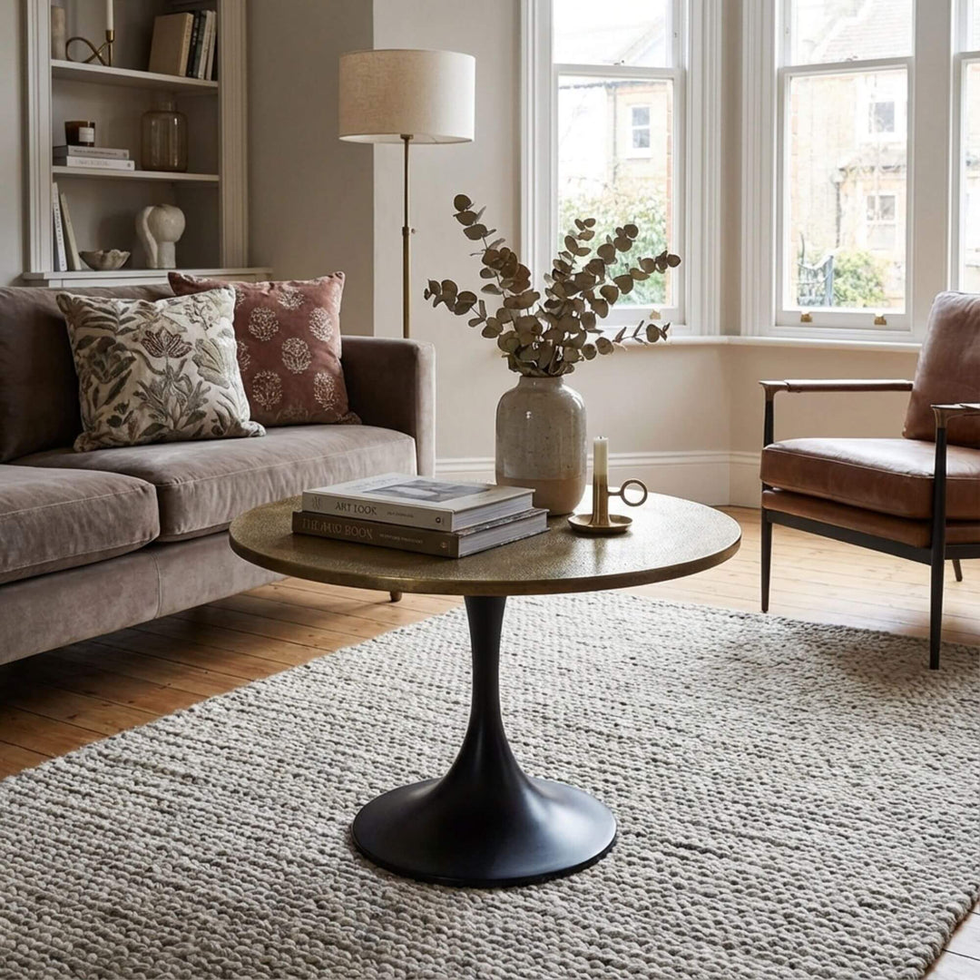 Living room with a Paros round coffee table, sofa, and armchair.