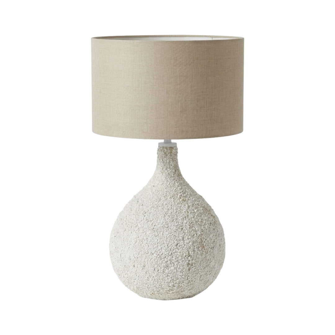 Front view of the Pemba table lamp showing its textured rounded base and linen shade.