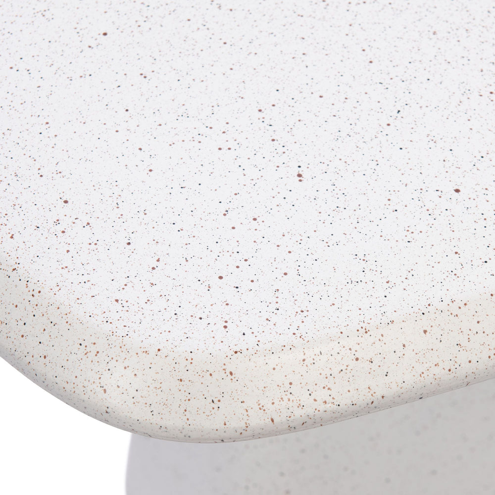 Close-up detail of the tabletop edge showing the warm off-white tone and subtle speckled mineral texture.