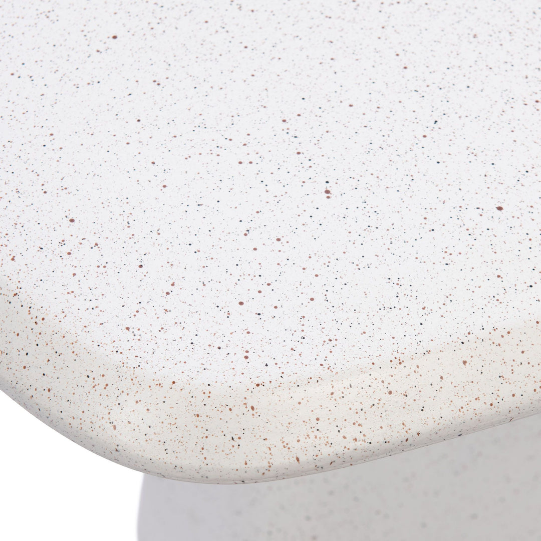 Close-up detail of the tabletop edge showing the warm off-white tone and subtle speckled mineral texture.