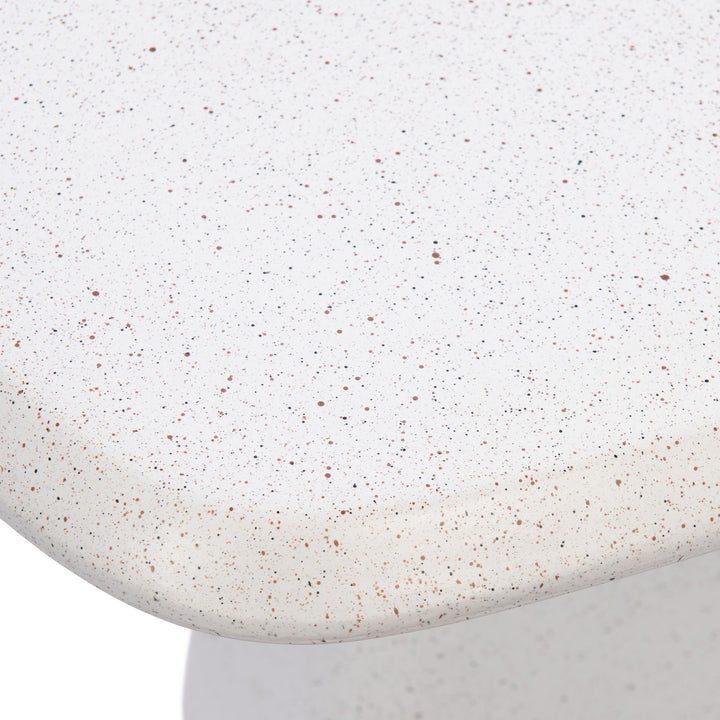 Close-up detail of the tabletop edge showing the warm off-white tone and subtle speckled mineral texture.