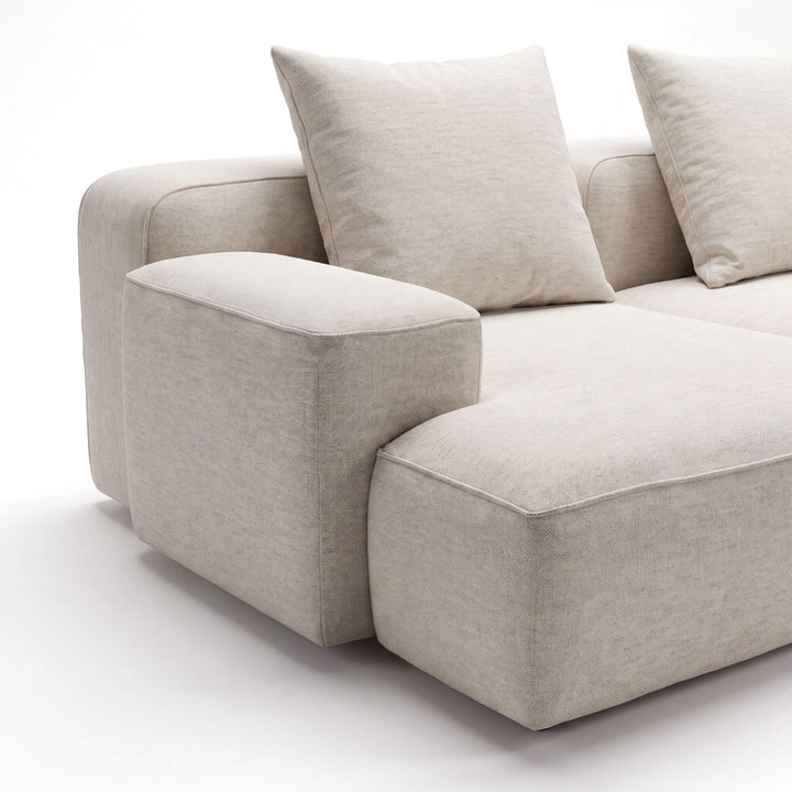 Close-up of the Positano sofa highlighting the wide armrest, deep chaise seat, and textured neutral upholstery