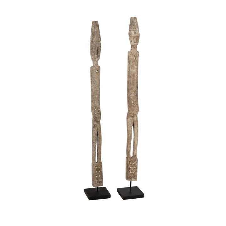 Front view of the Quitos wood sculpture highlighting its tall carved silhouette and metal base.