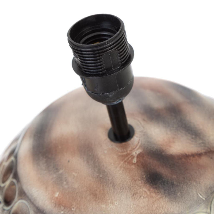 Detail of the Radon table lamp socket and neck above the patterned iron body.