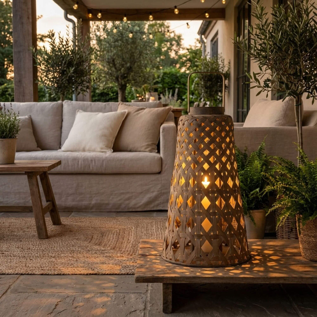 Styled outdoor setting featuring the Ralla lantern creating warm ambient light on a terrace.