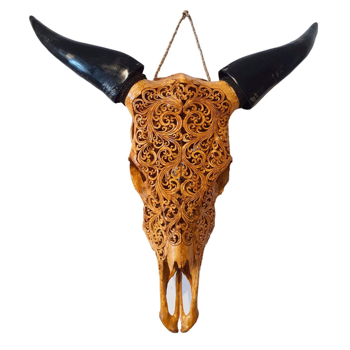 Hand-carved natural bone skull with dark horns and intricate floral details, Raraku Skull.

