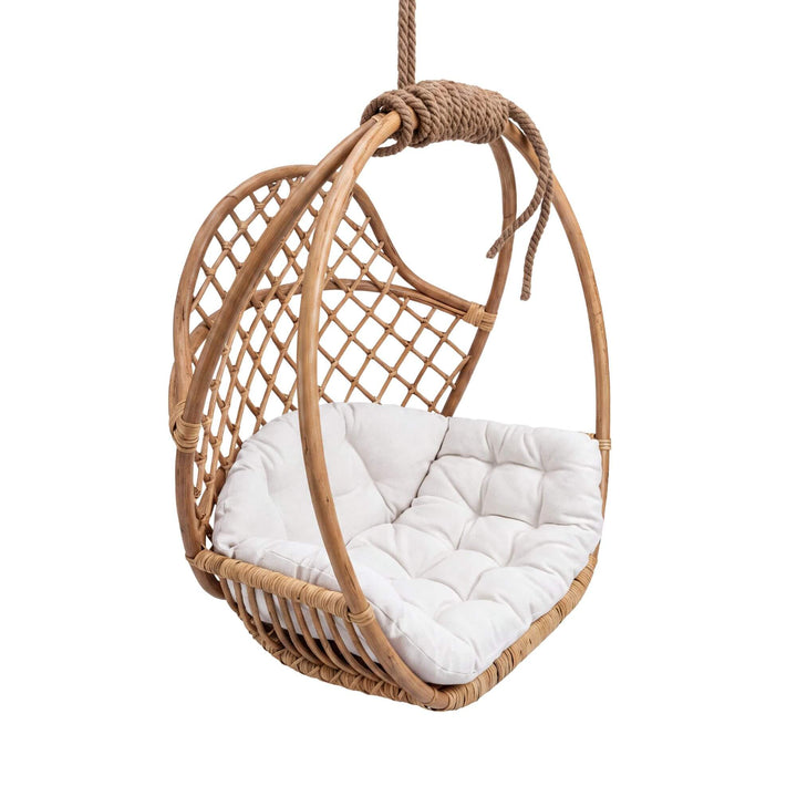 Front angled view of the Rattan Nest hanging chair with a natural woven rattan frame and cocoon-shaped design