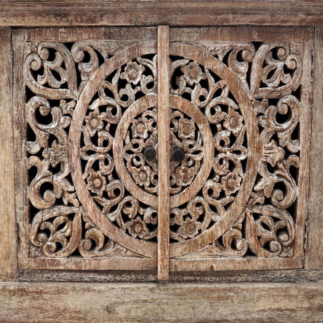 Close-up detail of the carved circular motif showing the handcrafted teak wood texture.