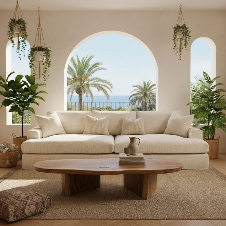 Living room with a beige Rimini sofa, wooden coffee table, and plants.