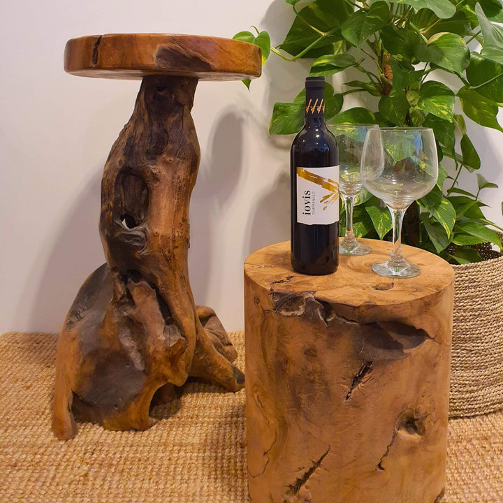 RURUTU TEAK ROOT STOOL IN A LIVING ROOM WITH A WINE BOTTLE AND GLASSES ON TOP