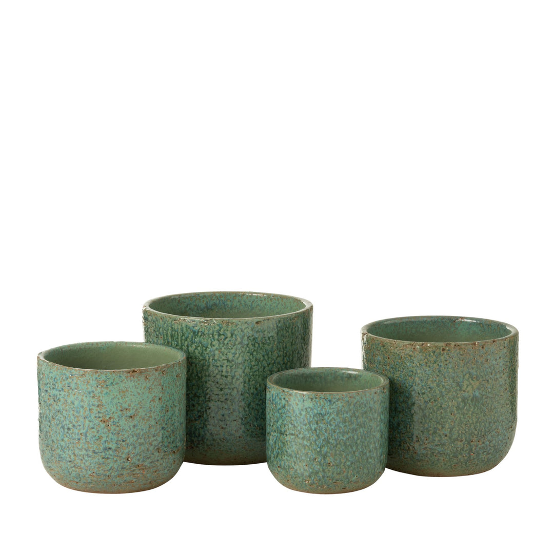 Group of rustic ceramic pots in green tones displayed together.