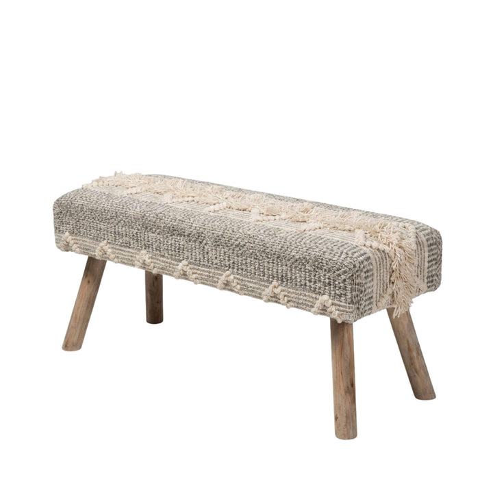 Front view of the Saga bench showcasing its woven jute and cotton seat and teak branch wood legs.