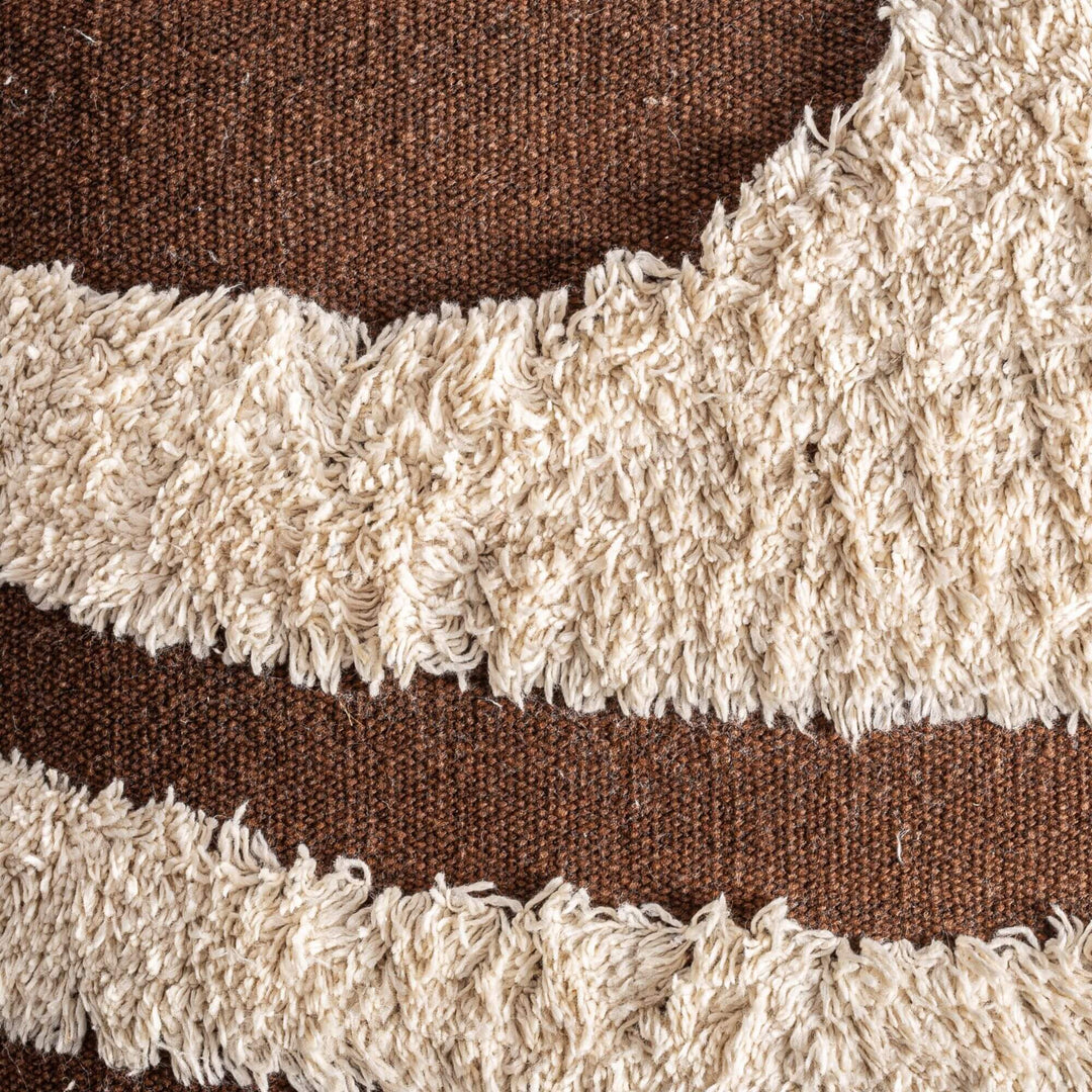 Close-up detail of the tufted cream pattern on the brown woven fabric.
