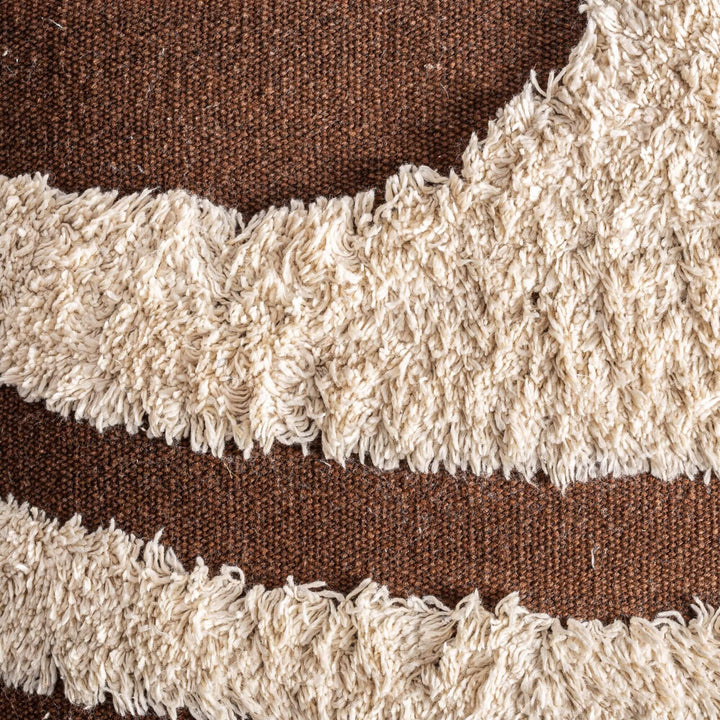 Close-up detail of the tufted cream pattern on the brown woven fabric.