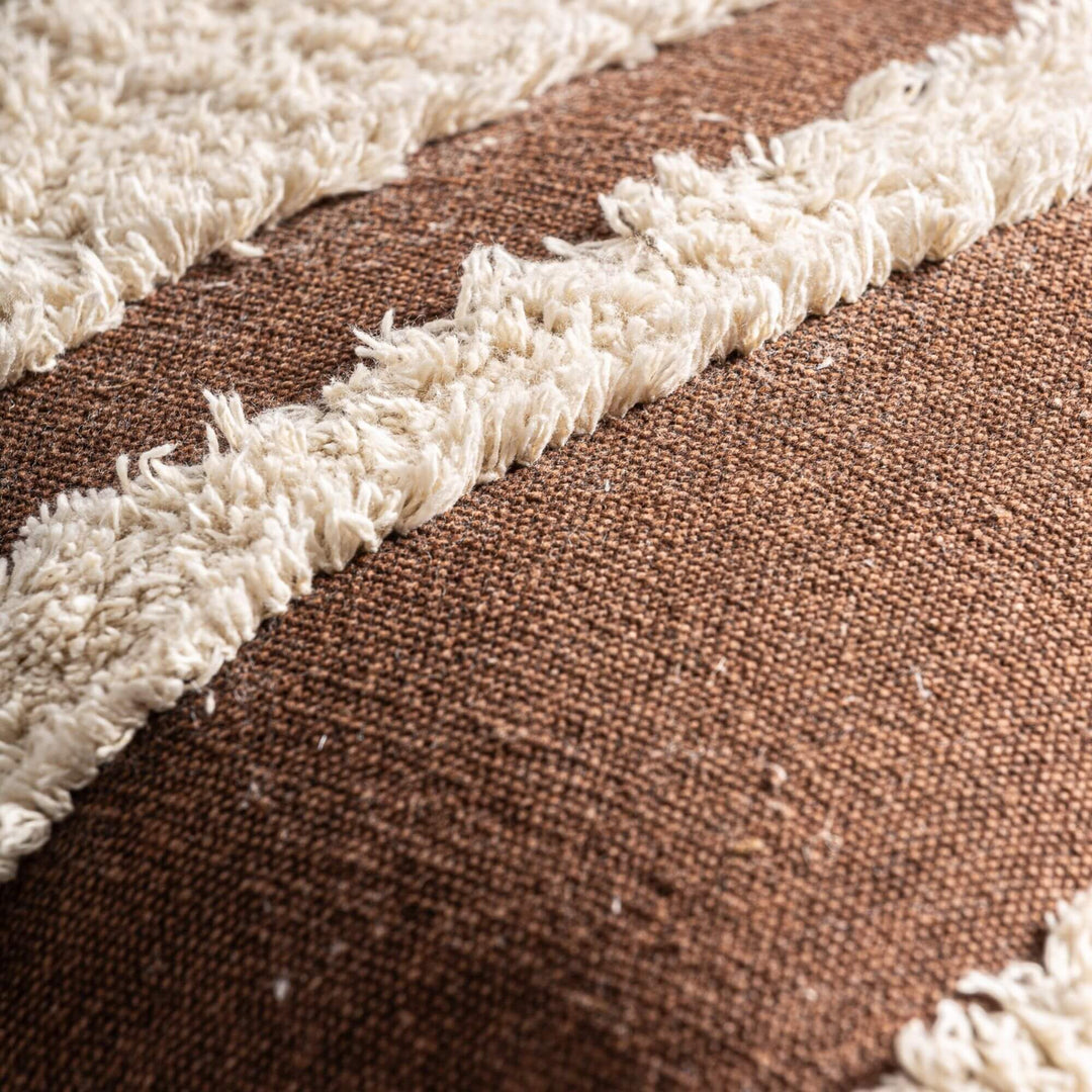 Close-up of the cushion surface showing the contrast between the textured tufting and woven base.
