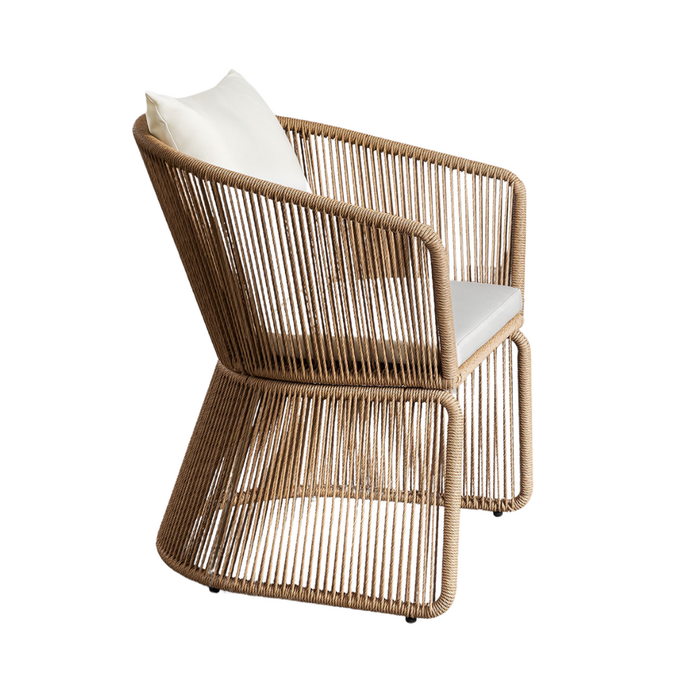 Side angle showing sculptural armrest and woven synthetic wicker seat.