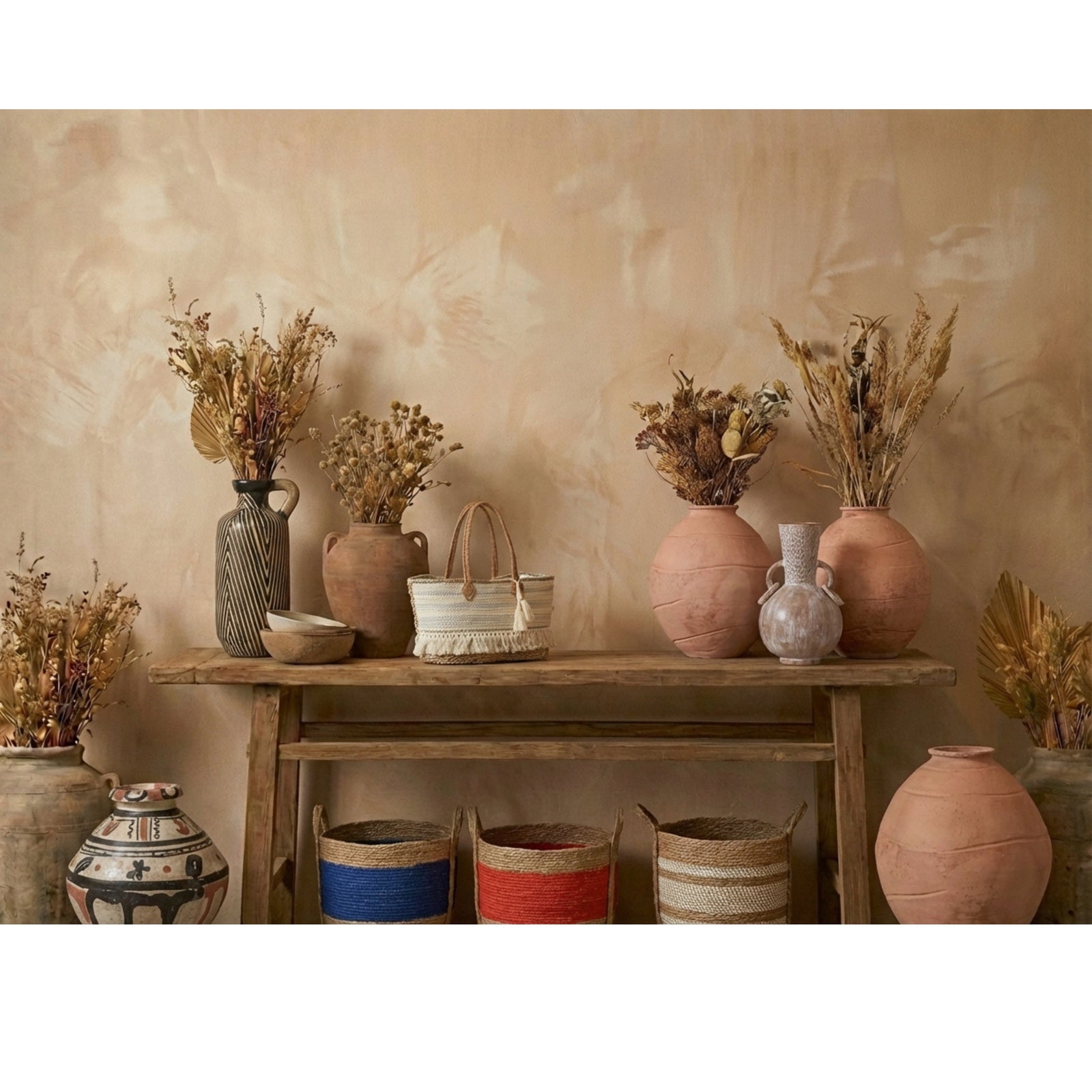 Vases and decorative items on a wooden shelf against a beige wall