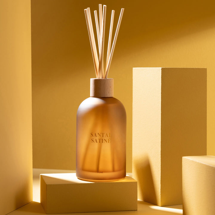 Santal Satiné Diffuser styled on a decorative shelf with warm lighting.
