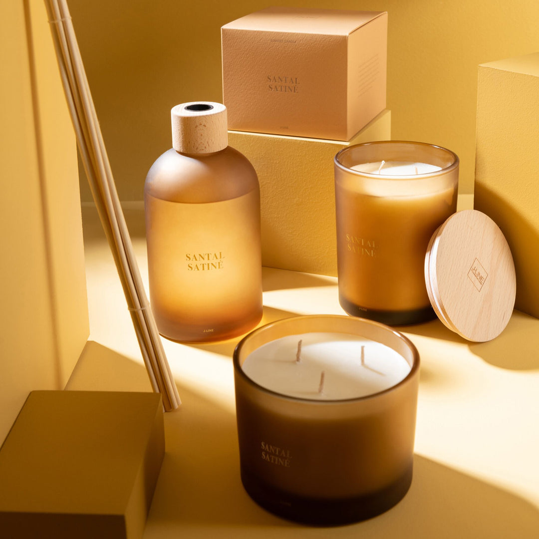 Group shot of Santal Satiné scented candle collection in various sizes.