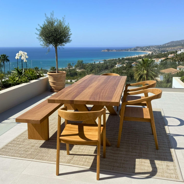 Outdoor terrace setting featuring the Santorini teak dining table beside the sea.