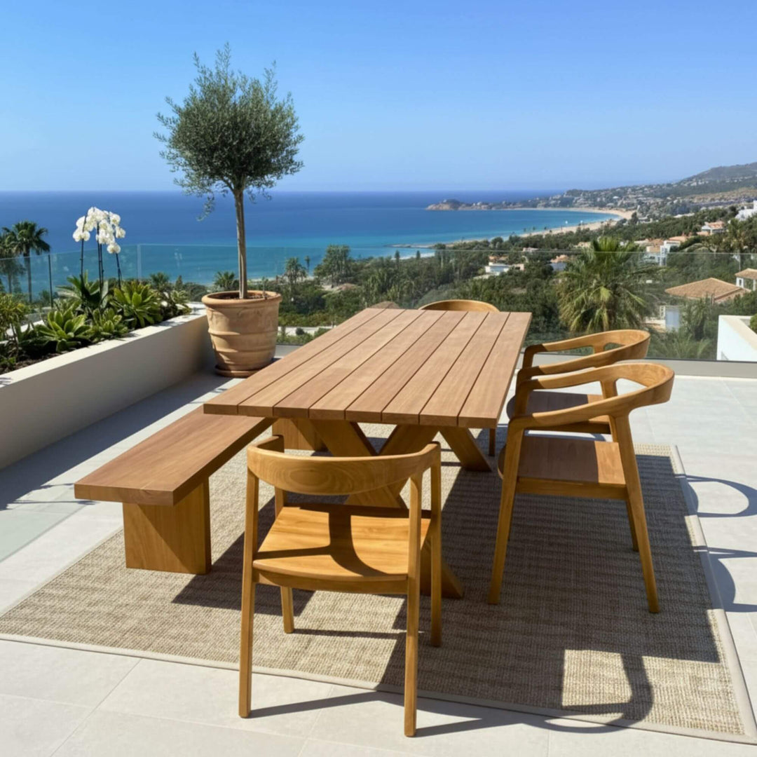 Outdoor terrace scene featuring the Santorini teak dining table with sea views.