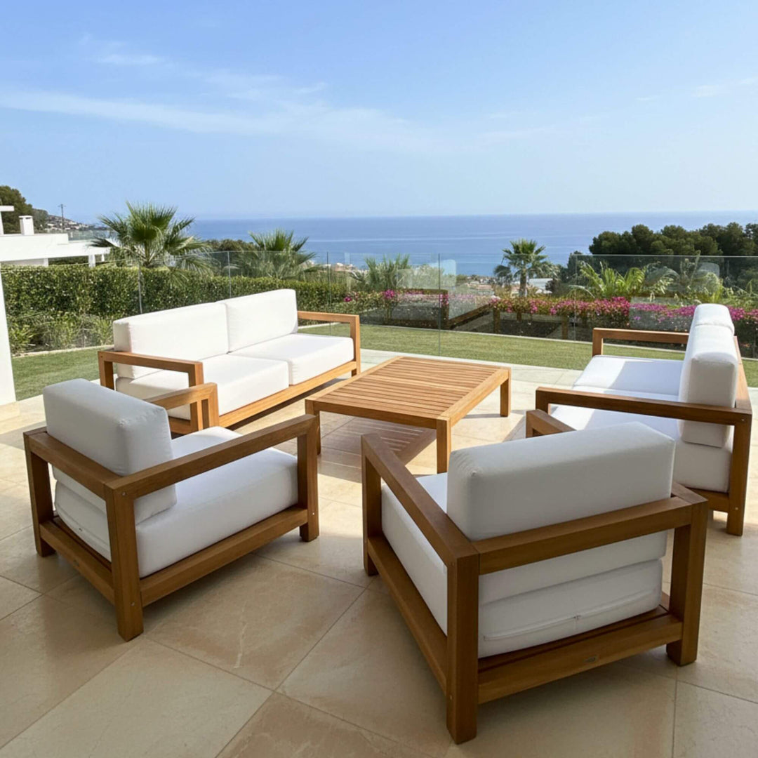 Outdoor setting showcasing the Santorini teak sofa on a terrace with sea views.