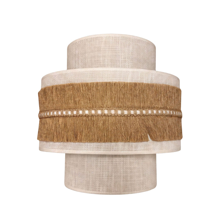 Front view of the Sapi wall lamp showing its layered fabric shade and natural jute fringe detailing.