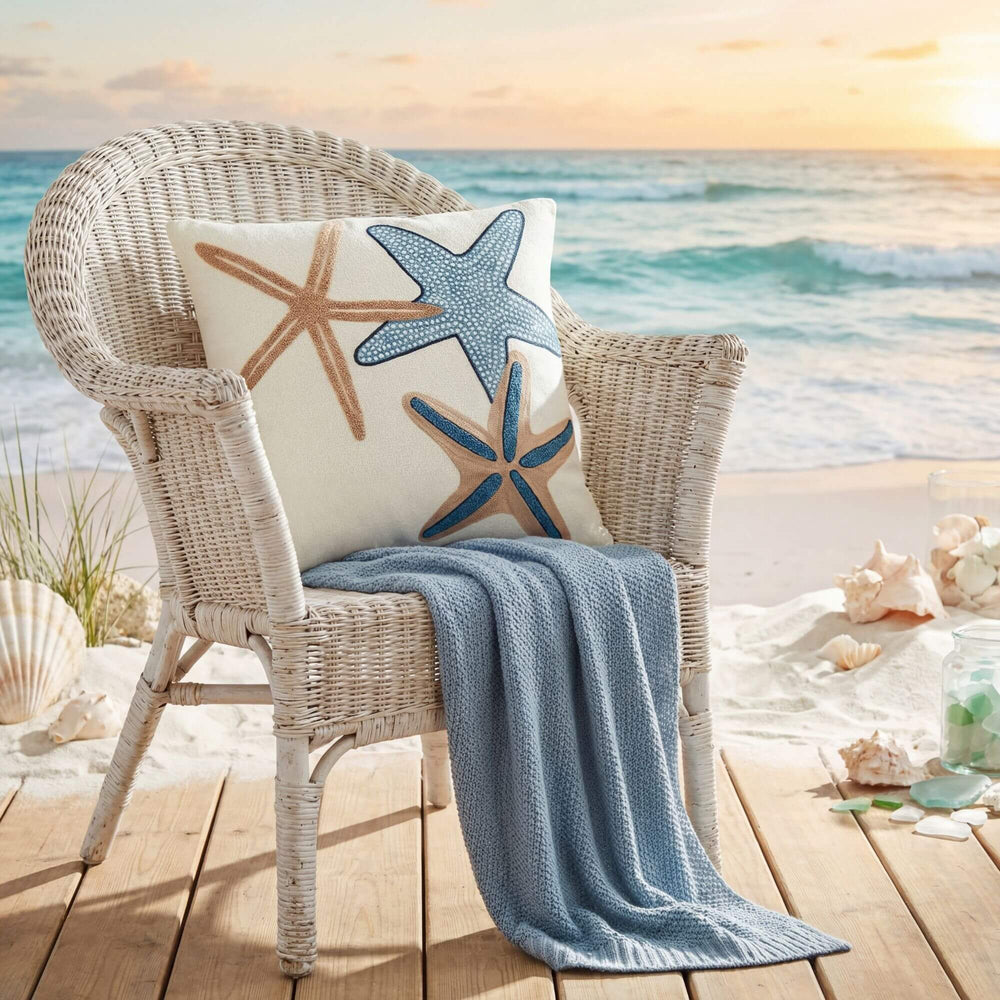 Front view of the Seastar cushion showing embroidered starfish motifs in blue and sand tones.